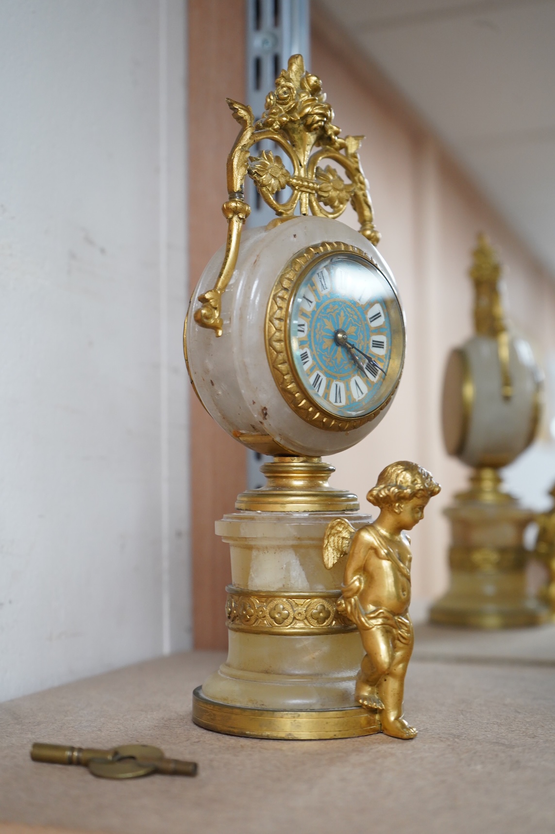 A late 19th century French ormolu and alabaster timepiece with painted dial and key, 24cm high